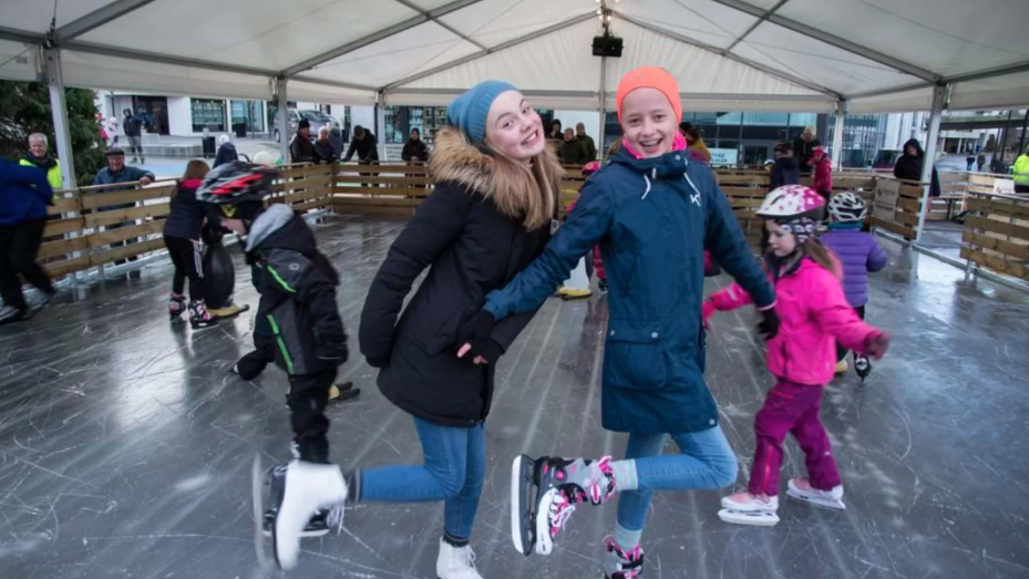 Glade jenter med skøyter på en av våre mobile isbaner